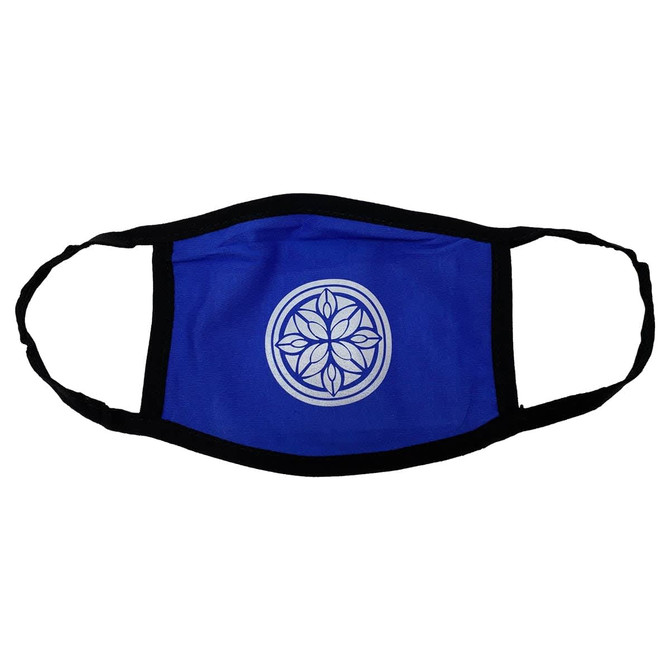 A blue cotton face mask with a black trim and a circular floral emblem in the centre.