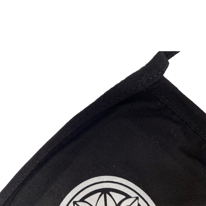 A black cotton face mask with a silver logo on the front and a stitched edge.