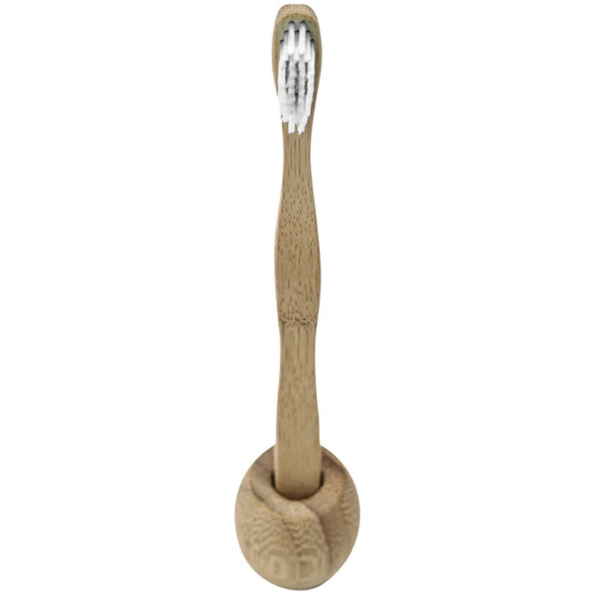 A bamboo toothbrush with a natural wood finish and white bristles, placed in an upright holder.