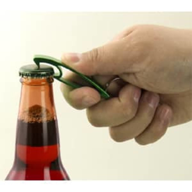 A drink bottle opener in green being used to remove a cap from a glass bottle with a vibrant liquid inside.