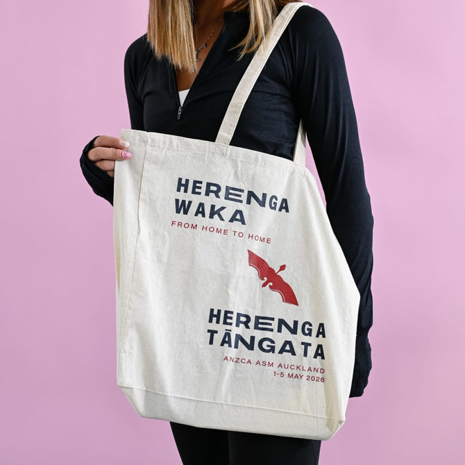 A calico tote bag with a gusset, featuring a logo and text in navy and red on a cream background.