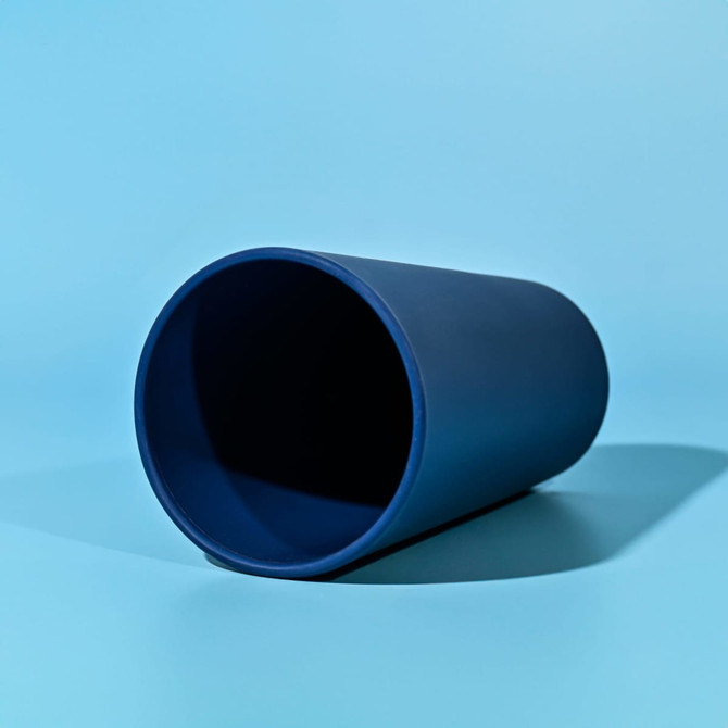 A drink bottle in a deep blue colour, featuring a simple design and a branding logo.