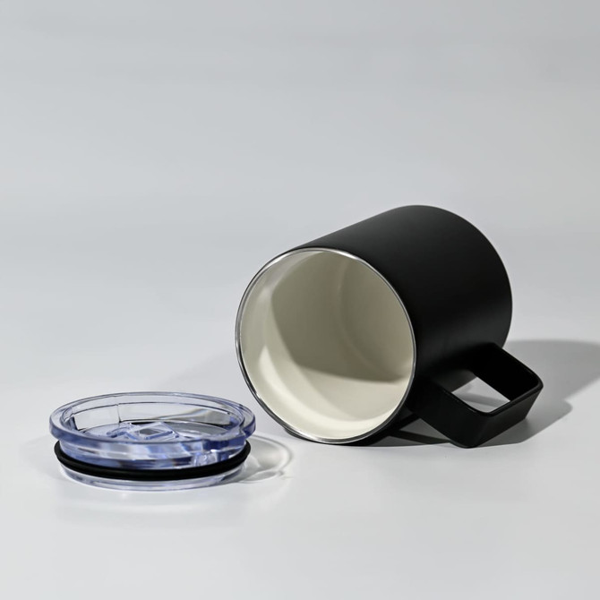 A black travel mug and a clear lid, featuring a handle and a smooth interior.
