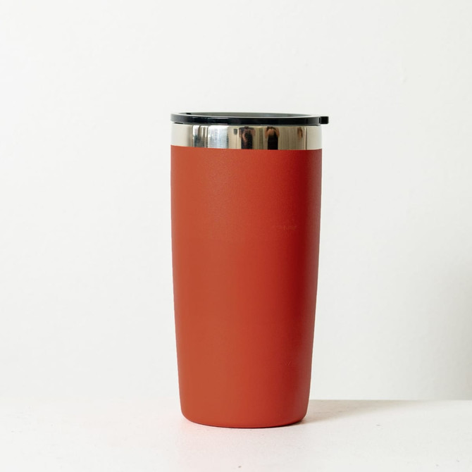 A drink bottle in a rust orange colour with a stainless steel rim and a black lid. It has a logo on the side.
