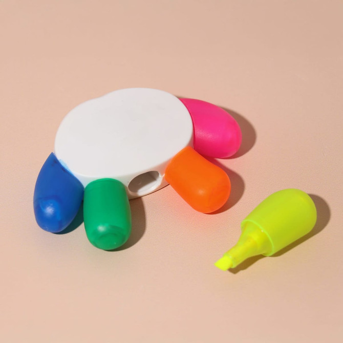 A set of highlighters in pink, blue, green, and orange, with a white holder. One yellow highlighter is placed beside it.