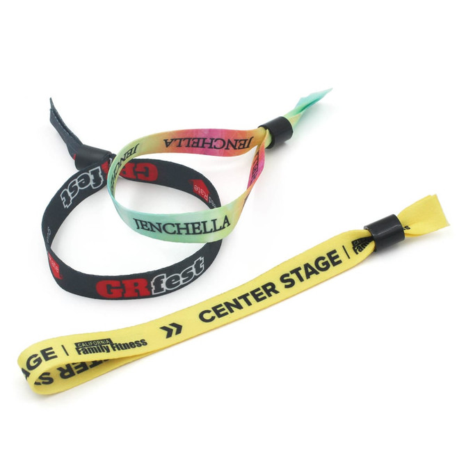 Three event wristbands in black, yellow, and multicoloured designs, featuring various logos and branding.