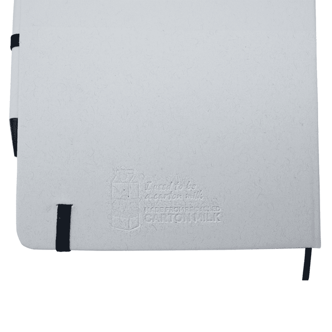 A white A5 notebook with a black elastic band and a black pen, featuring a subtle embossed logo.