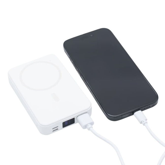 A white 5000mAh wireless charging power bank next to a smartphone, both connected with a charging cable.