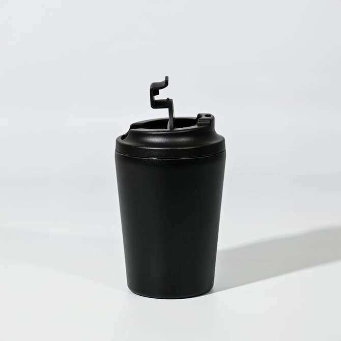 A travel mug in black with a flip-top lid and a logo. Ideal for beverages on the go.