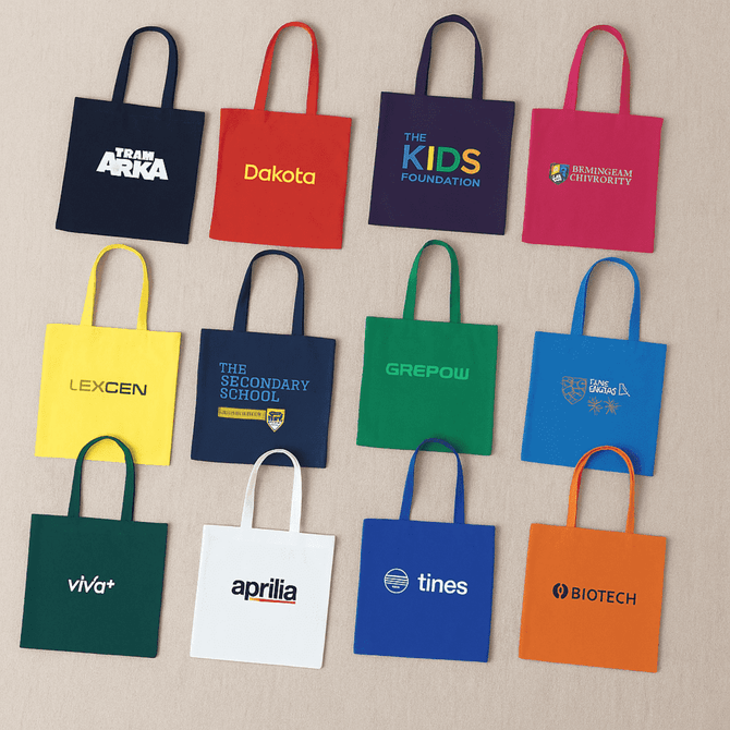 A collection of colourful tote bags in green, blue, red, purple, and black, featuring various logos.
