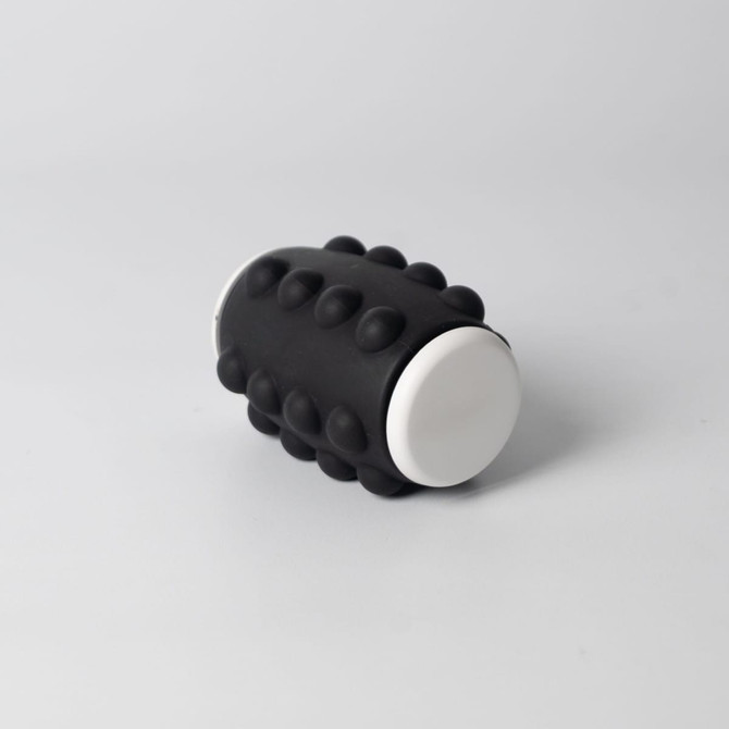 A black and white Whirl Popper Spinner featuring raised bumps on its surface, designed for interactive play.