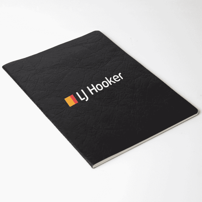 A black Velour DuPont A5 notebook with a textured cover and a logo on the front.