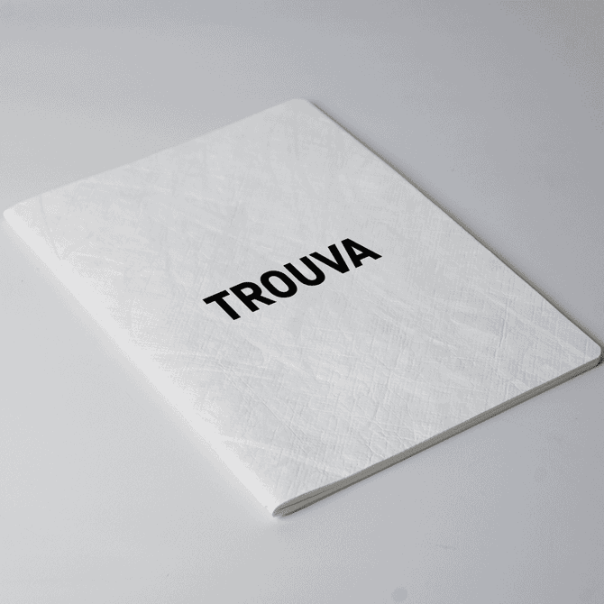 A white A5 notebook with a textured cover and a black logo on the front.