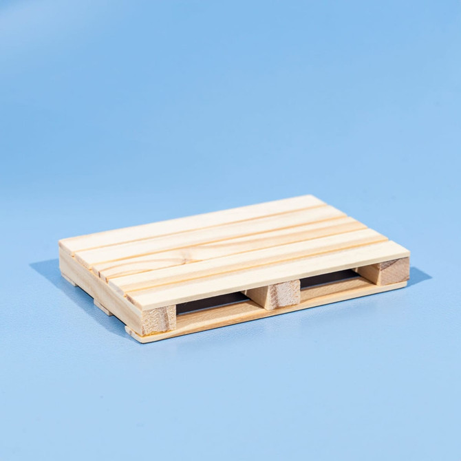 A wooden coaster designed to resemble a miniature pallet, featuring a natural light wood finish.