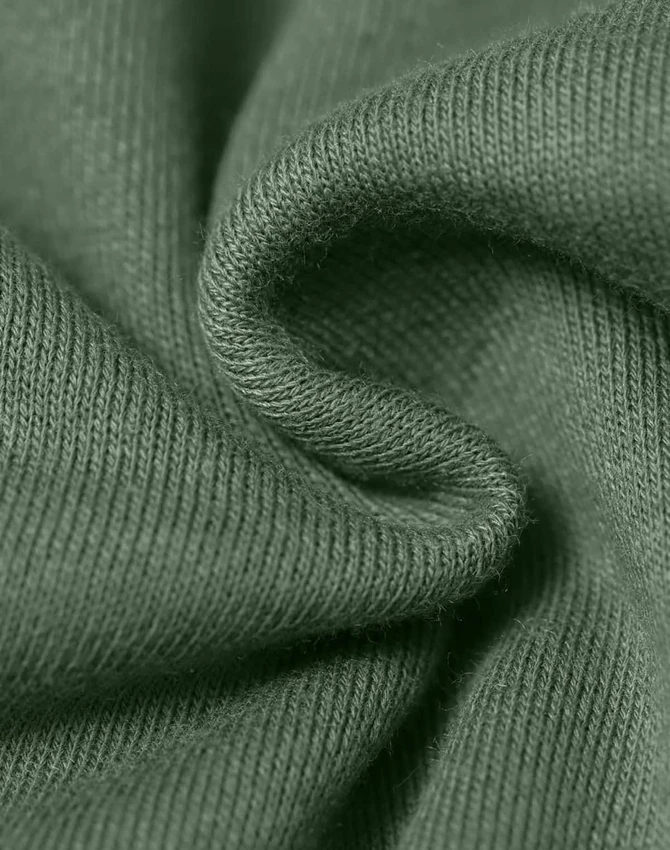A close-up of textured fabric in a muted green colour, highlighting its soft and snug qualities.
