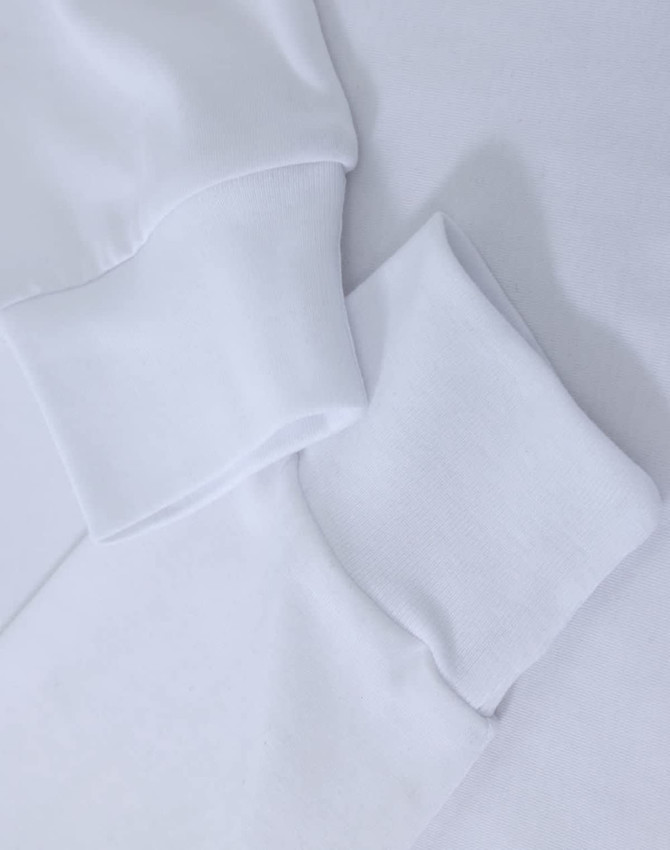 A white long-sleeve tee shirt with cuff details, featuring a subtle logo.