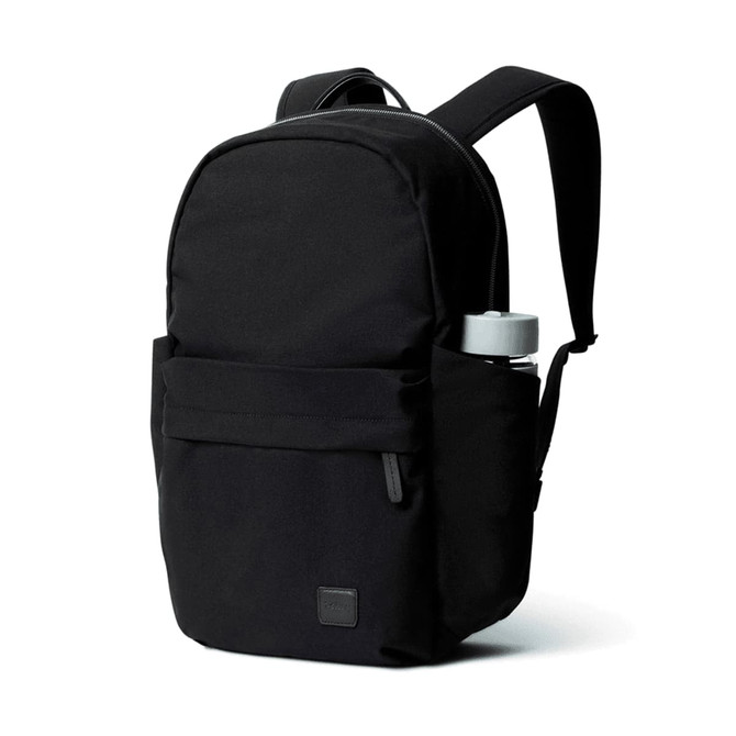 A black daypack with a front pocket and a drink bottle holder on the side, featuring a logo.