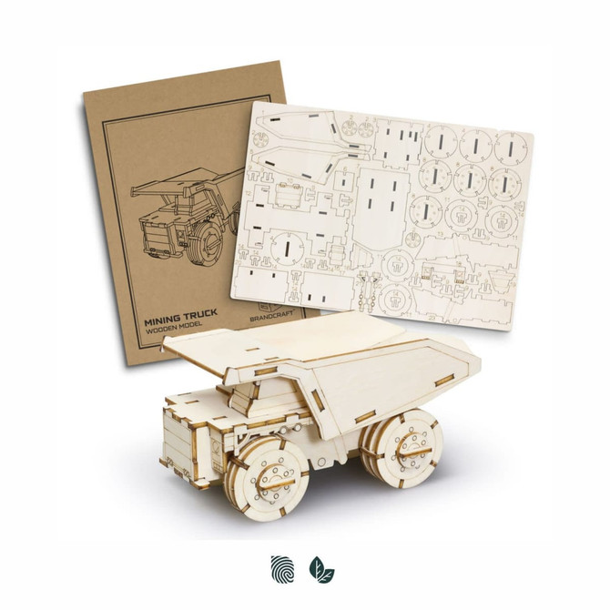 A wooden model of a mining truck with a flatbed, accompanied by a brown assembly sheet and a detailed cut-out sheet.
