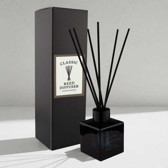 A black square reed diffuser with several black reeds, accompanied by a black box featuring a logo.