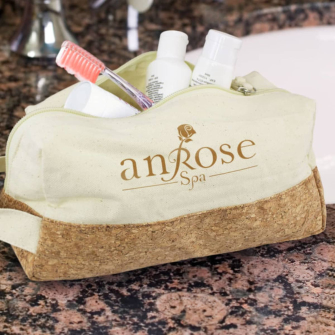 A beige toiletry bag with a cork base, containing various personal care products and a toothbrush. It features a logo.