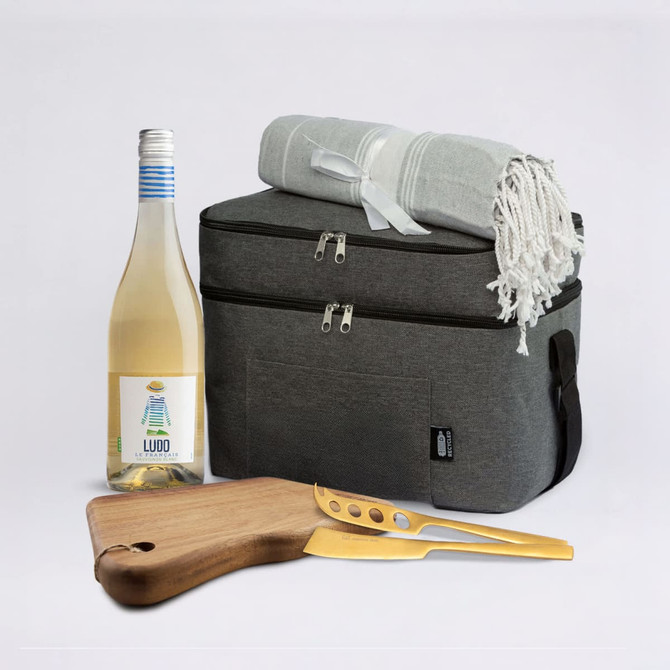 A drink bottle, picnic blanket, wooden cutting board with knife, and a grey cooler bag. The drink bottle is white.