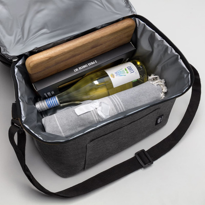 A drink bottle and a blanket inside a grey cooler bag, with a wooden board on top and a black box.