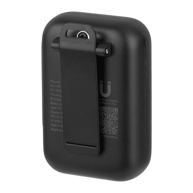 A black magnetic Bluetooth speaker with a clip on the back for easy attachment. The speaker also features a logo.