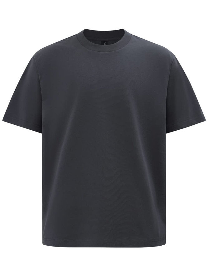 A black unisex heavy cotton oversized tee featuring a simple design and a round neckline. It has a logo on it.