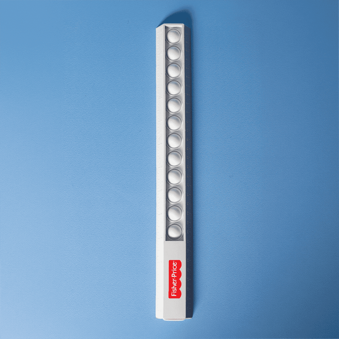 A white popper ruler featuring multiple poppers along its length and a small logo.