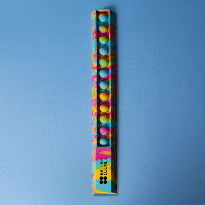A 30cm popper ruler featuring a vibrant design with blue and multicoloured dots, alongside a logo.
