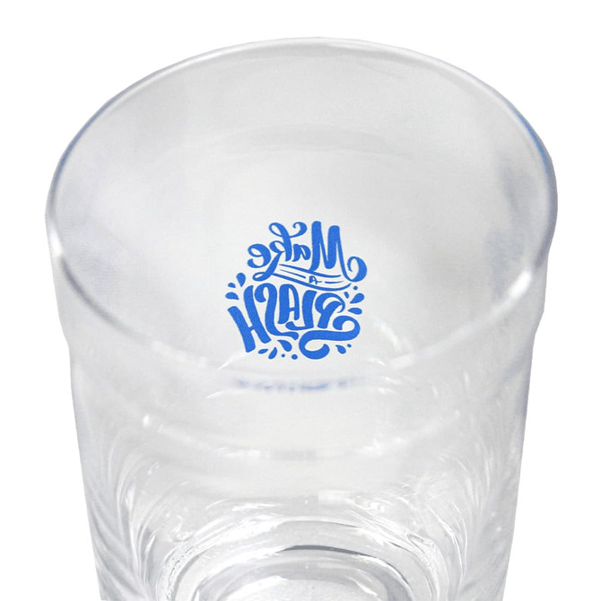 A clear glass carry cup featuring a decorative design inside and a smooth surface. It has a logo on the inside.