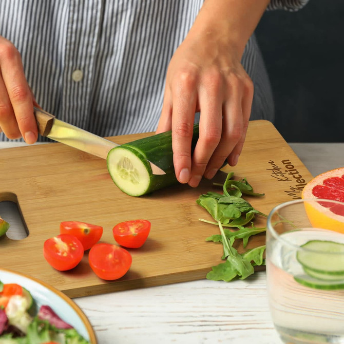 A bamboo rectangle chopping board in a brown cardboard packaging, featuring a logo on the front.