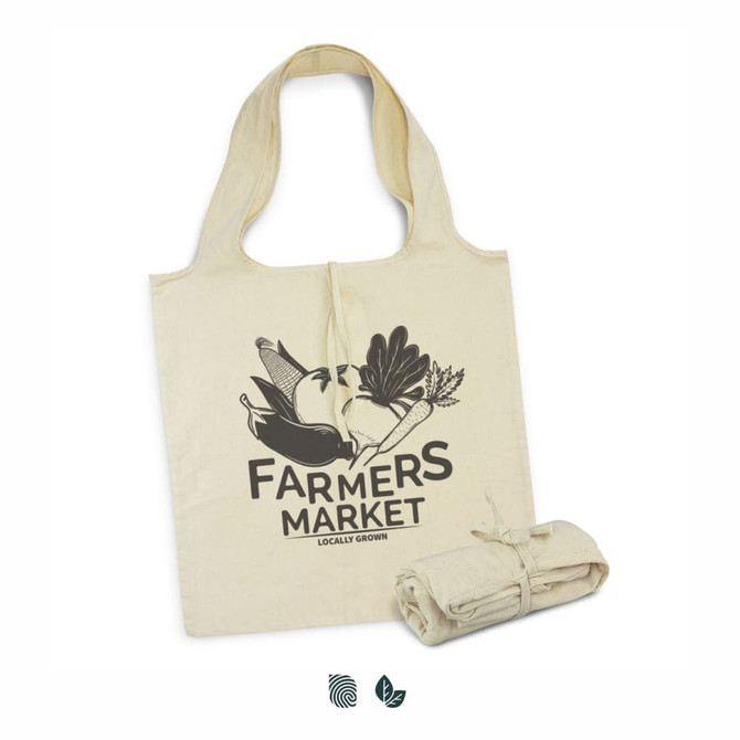 A cream-coloured foldaway tote bag featuring a graphic design and a logo, neatly rolled and tied next to it.