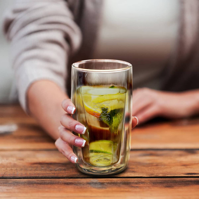 A drink bottle featuring a double wall design, holding green liquid and lime slices, clear glass with a branding logo.