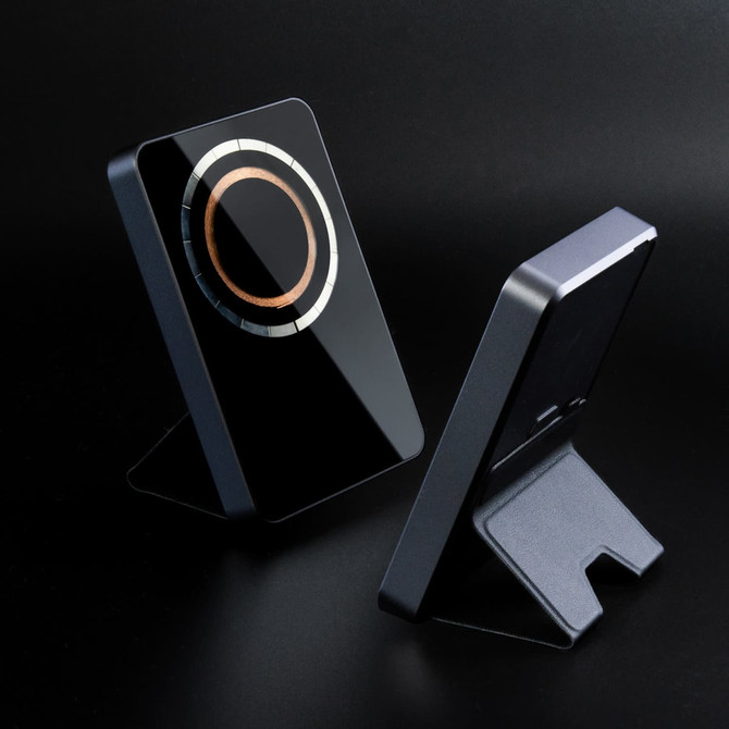 A black wireless charging power bank with a sleek design and a stand, featuring a circular charging area.