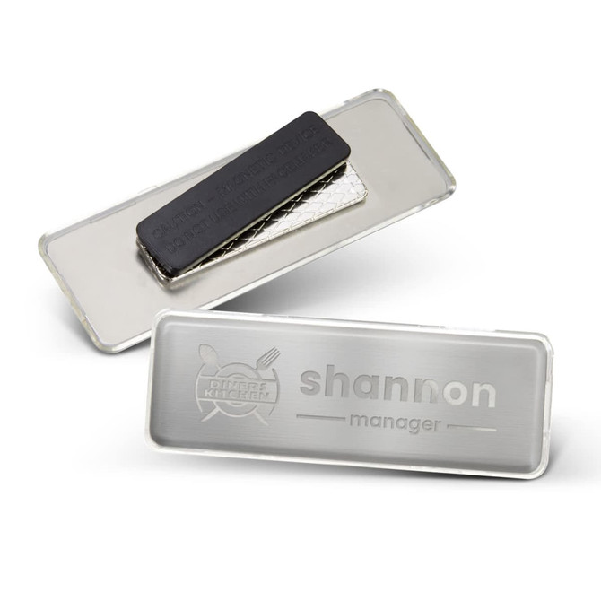 A metal name badge in silver, featuring a black magnetic backing and an engraved name plate.