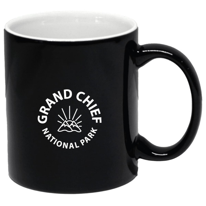 A black coffee mug with a logo featuring mountains and sunburst design. Holds 300ml.