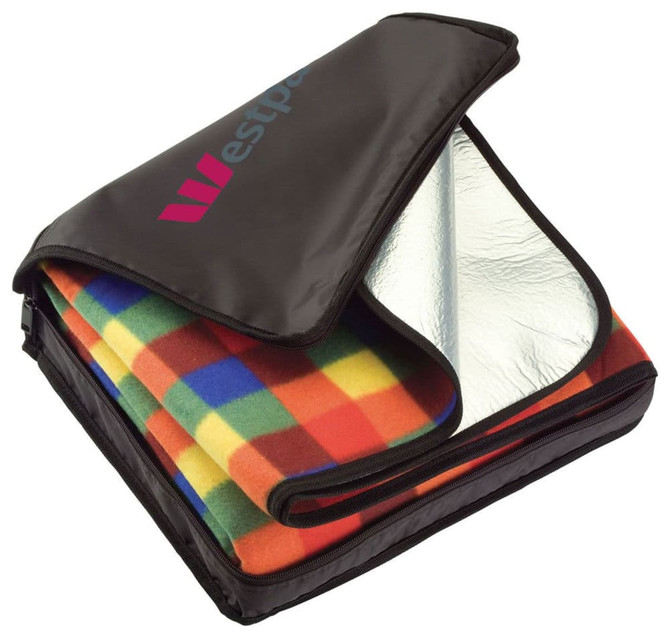 A picnic rug with a colourful checkered pattern, neatly packed in a black carry bag with a logo.