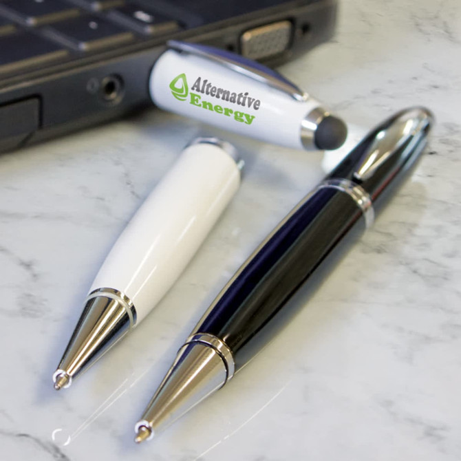 A collection of metal pens including a white pen and a black pen, featuring a logo on one, placed beside a laptop.