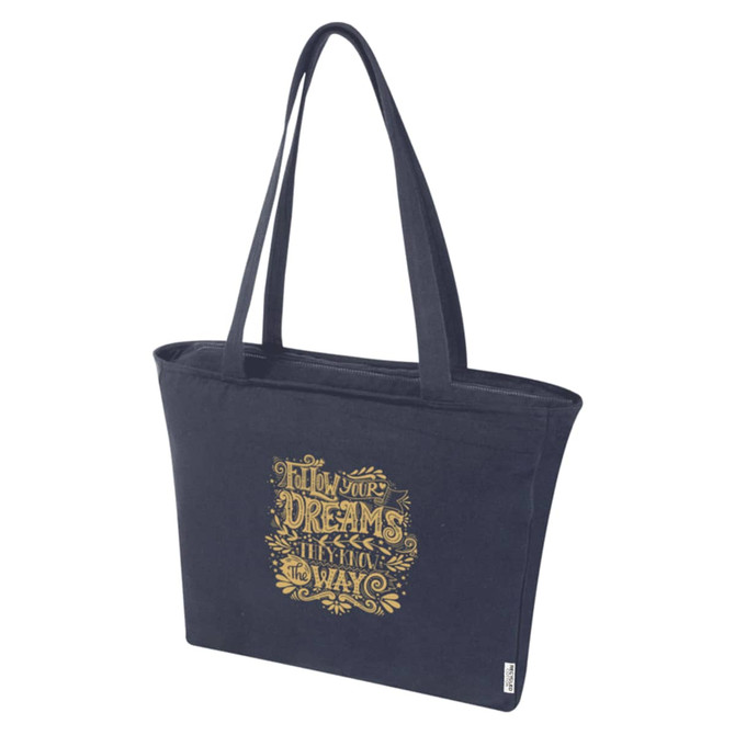 A navy zip tote bag with a gold graphic design and sturdy handles, featuring a logo.