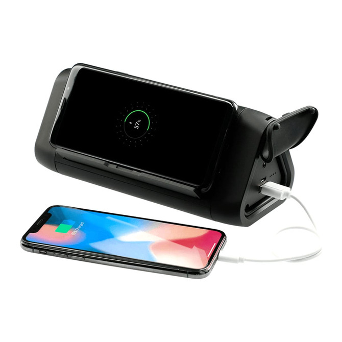 A black power bank and speaker with a smartphone charging on one side and another smartphone placed nearby.