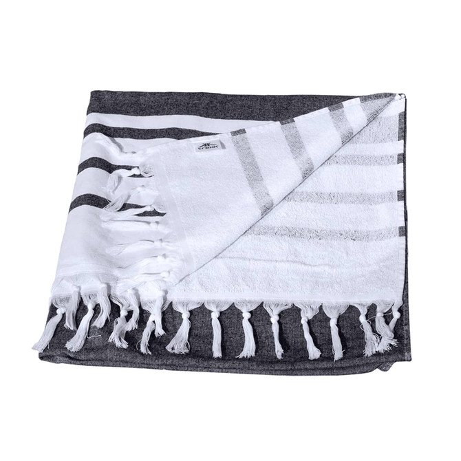A Turkish beach towel with a dark grey and white striped design, featuring fringed edges and a small logo.