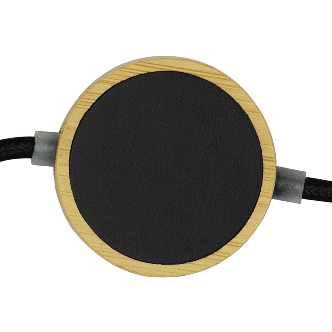 A round black charging pad with a bamboo border and a braided cable, designed for wireless charging.