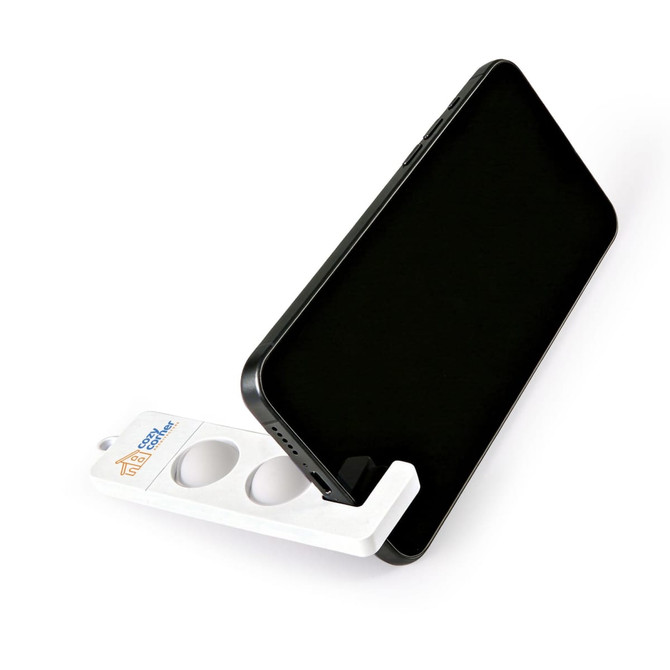 A white phone stand securely holding a black smartphone, featuring a logo on its base.