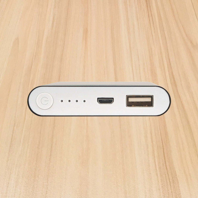 A white power bank with a USB port, a micro USB port, and indicator lights, viewed from the top.