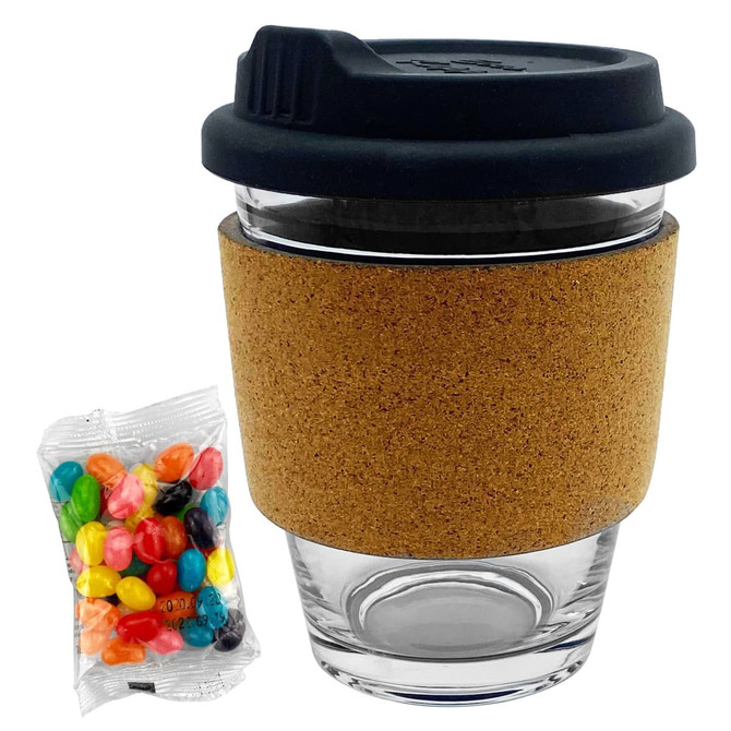 A glass coffee cup with a cork band and a black lid, accompanied by a pack of colourful jelly beans.