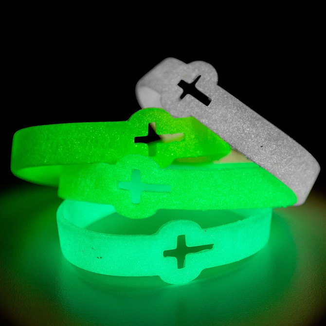Three neon glow silicone wristbands in green and white stacked together, featuring a cross design and glowing in the dark.