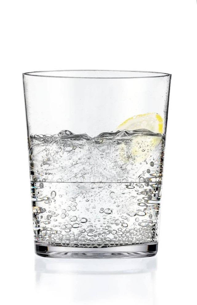 A glass tumbler filled with sparkling water and a slice of lemon, featuring a clear design and bubbles.