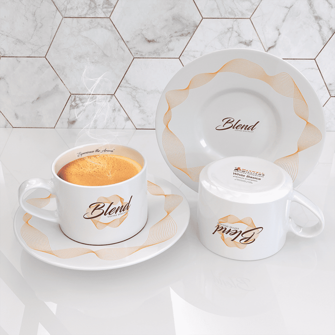 A white straight cup and saucer featuring a decorative design and a logo, showcasing steaming coffee.