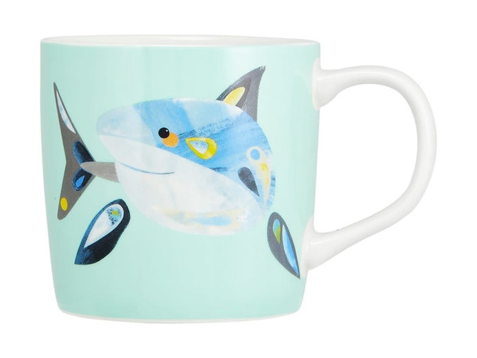A coffee mug featuring a blue and white shark design on a mint green background, with a handle and a logo.